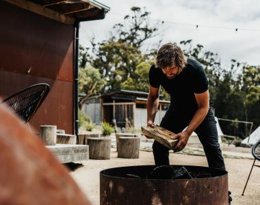 man adding wood fire